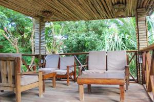 two chairs and a table on a porch at Sagando Bungalow in Michamvi