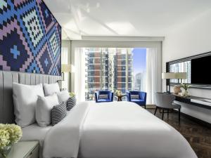 a bedroom with a large white bed and a large window at Pullman Dubai Downtown in Dubai