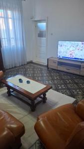 a living room with a coffee table and a flat screen tv at House on the road in Telti