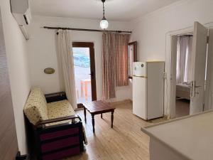 a living room with a couch and a refrigerator at Eucalyptus Pension in Patara
