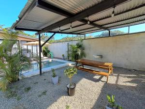 a patio with a wooden bench and a pool at Casa Congo Puerto Viejo in Puerto Viejo