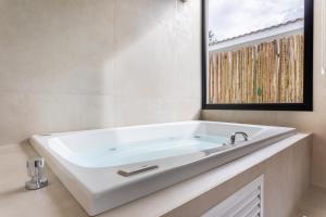 a white bath tub in a bathroom with a mirror at Botanique Veadeiros in Alto Paraíso de Goiás +19 photos