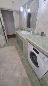 a bathroom with a washing machine and a sink at House on the road in Telti +8 photos