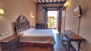 a bedroom with a large bed and a tv in it at Hotel Altamira in Santillana del Mar