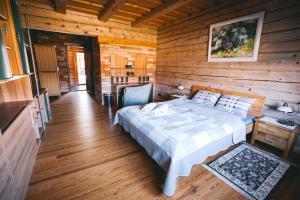 a bedroom with a bed in a log cabin at Amoliņi in Mērsrags +47 photos