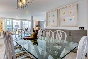 a dining room with a glass table and chairs at Seafront villa with jacuzzi in Maspalomas