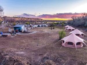a group of tents in a field with a parking lot at Bisti Badlands Tent in Farmington +14 photos