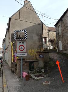 a speed limit sign on a street next to a building at Studio de charme in Lormes +3 photos
