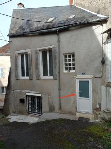 a small white house with a door and a window at Studio de charme in Lormes