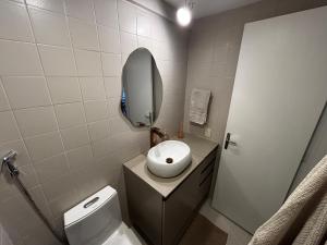 a bathroom with a toilet with a mirror and a sink at Lar de Noel in Rio de Janeiro +6 photos