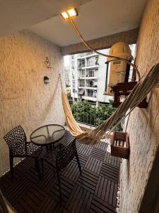 a hammock on a balcony with a table and chairs at Lar de Noel in Rio de Janeiro