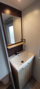 a bathroom with a white sink and a mirror at l' échappée belle in Mimizan-Plage +7 photos
