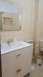 a bathroom with a white sink and a mirror at Moradia Vinhais in Vinhais +3 photos