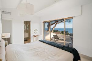 a bedroom with a bed with a view of the ocean at Corgona Villa in Cannes +55 photos