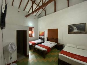 a hotel room with two beds and a tv at Hotel Casa Posada Don Chepe in San Gil