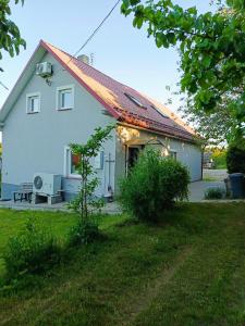 a small white house with a red roof at Przystanek Natura in Radzie