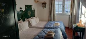 a bedroom with a bed with a green headboard at Mar e Sol in Vila Nova de Milfontes