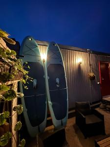 two surfboards are attached to a fence at night at Namiņš in Ragaciems