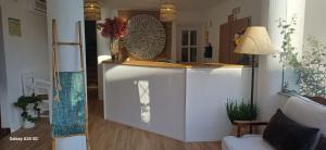 a living room with a white kitchen with a counter at Mar e Sol in Vila Nova de Milfontes