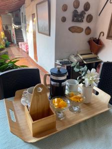 a wooden table with a tea pot and bowls of oranges at Hotel Casa Posada Don Chepe in San Gil