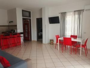 a living room with a table and red chairs at Dedalo affittacamere in Pompei +7 photos