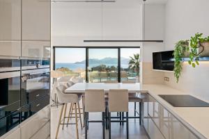 a kitchen with a dining table and a view of the ocean at Corgona Villa in Cannes