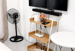 a room with a desk with a fan and a television at LJ CCC CozyNest at 32 Cebu Fast Wifi Netflix You tube in Cebu City