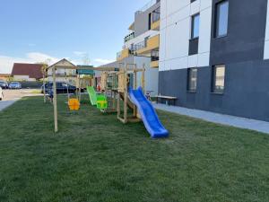 a playground with a slide in the grass next to a building at IDDA Concept 4 in Târgu-Mureş