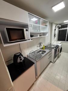 a small kitchen with a sink and a microwave at Lar de Noel in Rio de Janeiro