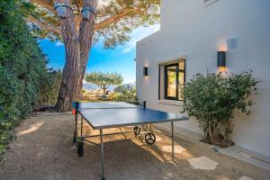 a ping pong table in front of a house with a tree at Corgona Villa in Cannes