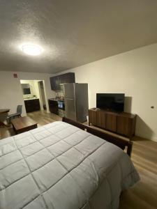 a bedroom with a large white bed and a kitchen at Green River Inn Apartments in Green River