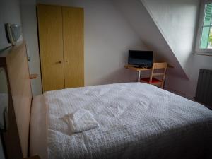 a bedroom with a bed and a desk with a laptop at Hotel BETHEL in Nevers +22 photos