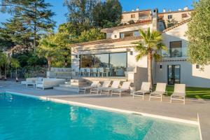 a house with a swimming pool next to a villa at Corgona Villa in Cannes
