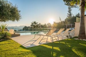a group of lounge chairs sitting next to a pool at Corgona Villa in Cannes