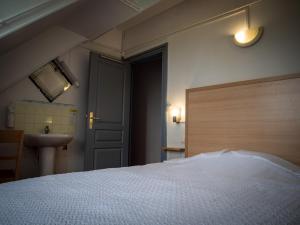 a bedroom with a white bed and a sink at Hotel BETHEL in Nevers
