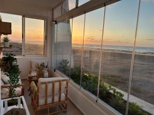 a room with large windows looking out at the ocean at Luxueux appartement front mer in Sidi Rahal
