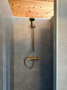 a shower with a hose attached to a wall at Meiriet1936 in Fjarland +64 photos