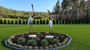 two statues of birds standing in a garden at Casa Kashubia - Kaszuby Domek nad jeziorem I cisza natura i luksus in Brzeźno Szlacheckie +75 photos