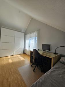 a bedroom with a desk with a computer and a bed at Green Living in Meckenbeuren