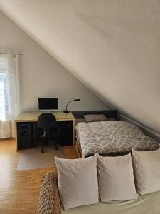 a bedroom with a bed and a desk with a computer at Green Living in Meckenbeuren