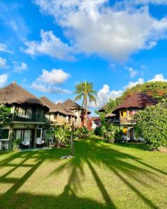 a resort with a green yard with houses at Pousada Barra Velha in Maragogi