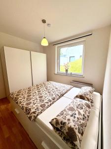 a bed in a small room with a window at Sorpesee Stay in Sundern