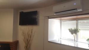 a living room with a television and a window at Moradia Vinhais in Vinhais