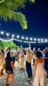 a group of people dancing on a beach at Pousada Barra Velha in Maragogi +114 photos