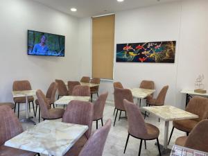 a dining room with tables and chairs and paintings on the wall at Hotel Kourkoumelata in Argostoli