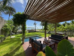 a wooden deck with a pergola and a swimming pool at Casa Mar - Os Navegantes in Amontada