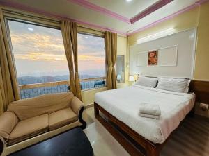 a bedroom with a bed and a chair and a window at Aizawl Hotel in Āīzawl