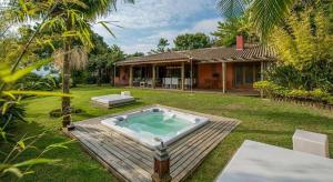 a backyard with a hot tub and a house at Pousada Quinta do Bucanero in Imbituba