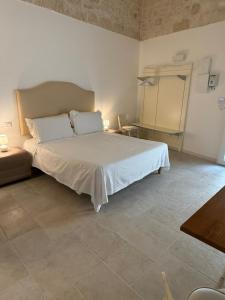 a bedroom with a large white bed in a room at Neptune Stone House in Molfetta