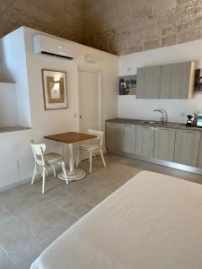 a kitchen with a table and chairs and a sink at Neptune Stone House in Molfetta +3 photos